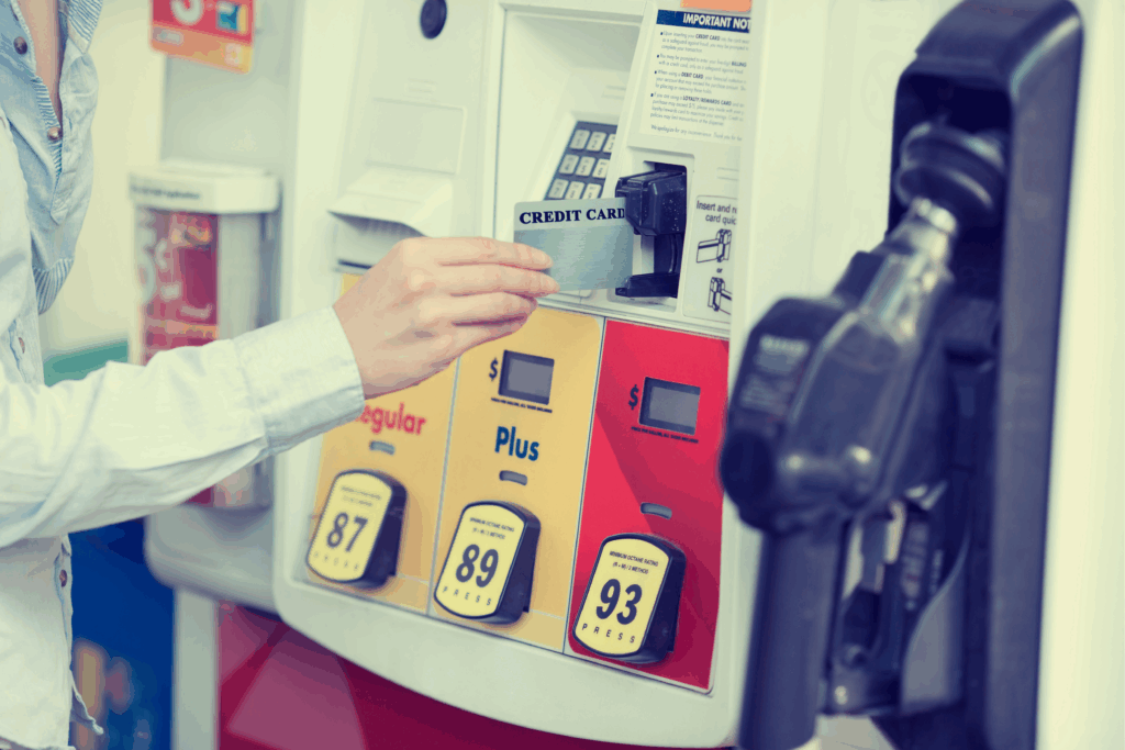 Woman paying to fill car with gas at gas station with credit card.