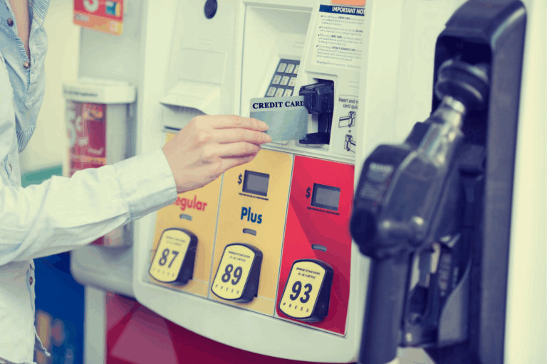 Woman paying to fill car with gas at gas station with credit card.